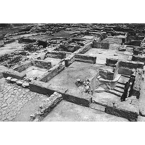Black and white photo of Figure 1.39. Malia, Quartier Mu, Building A, view looking northeast to lustral basin (right foreground), light-well (center background), and Minoan hall (right background). Poursat and Schmid 1992, fig. 28. Photo © École française d’Athènes.